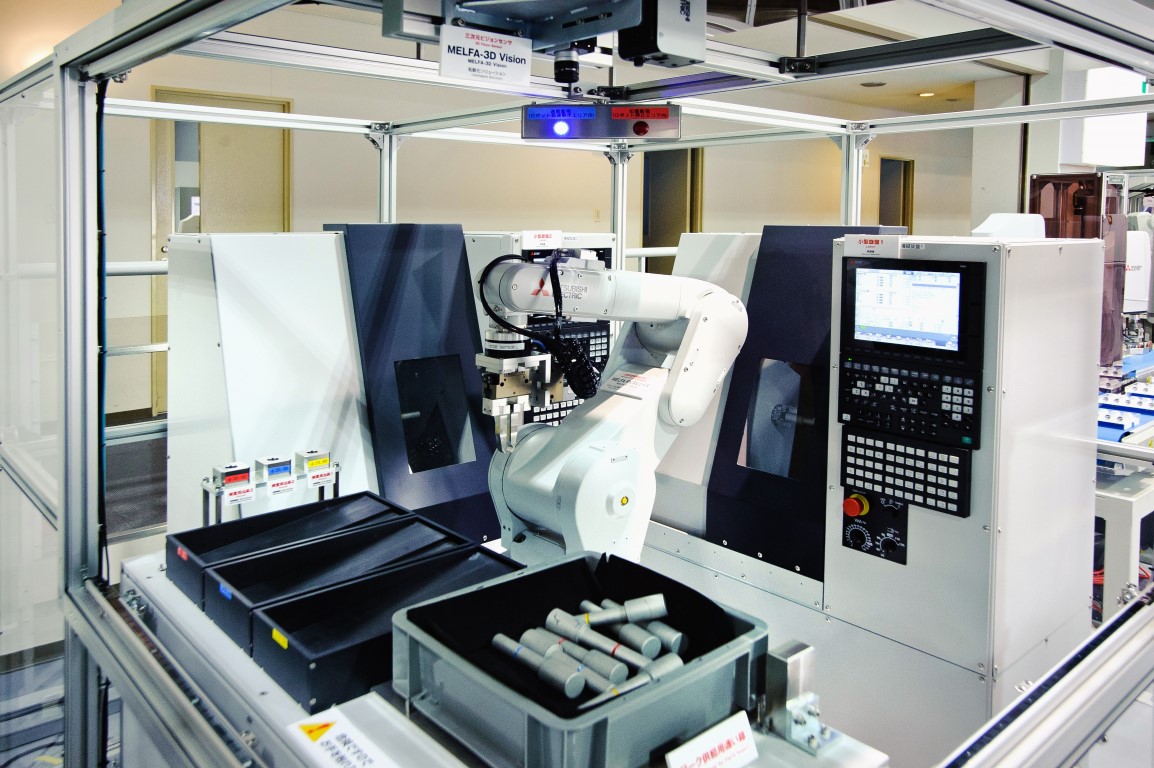 Showroom w Nagoya Works – widoczne m.in. maszyny i roboty przemysłowe ze zintegrowanymi systemami wizyjnymi, sterowane z wykorzystaniem platformy iQ.